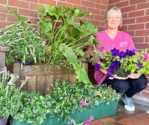 Staff next to a collection of plants